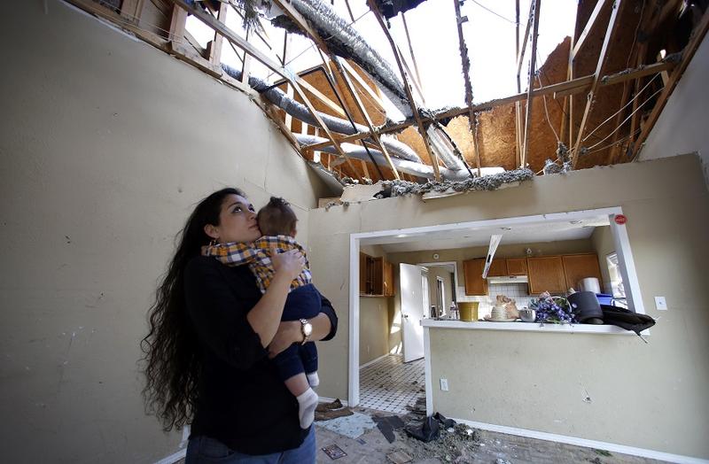 Lindsay Diaz and her son, 7-month-old Arian Krasniqui, in the livingroom of their Rowlett home where they hunkered down in the bathtub for safety during the December tornadoes. They have bounced around from family homes to hotels waiting on a temporary rent house to open up. Photographed Friday, February 19, 2016. (photo copyright Lara Solt)