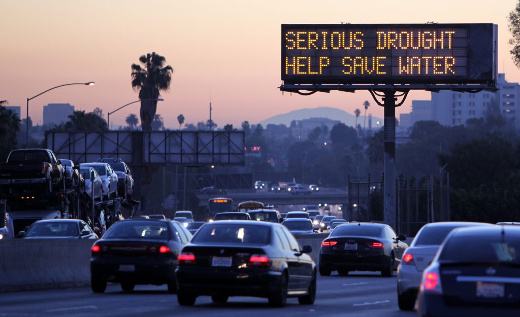 Morning traffic makes it's way toward downtown Los Angeles along the Hollywood Freeway past an electronic sign warning of severe drought on Friday, Feb. 14, 2014. California is taking to the highways to spread the word about water conservation after months of drought. This week the California Department of Transportation launched an education campaign with 700 electronic highway boards displaying the message: "Serious Drought. Help Save Water." (AP Photo/Richard Vogel)